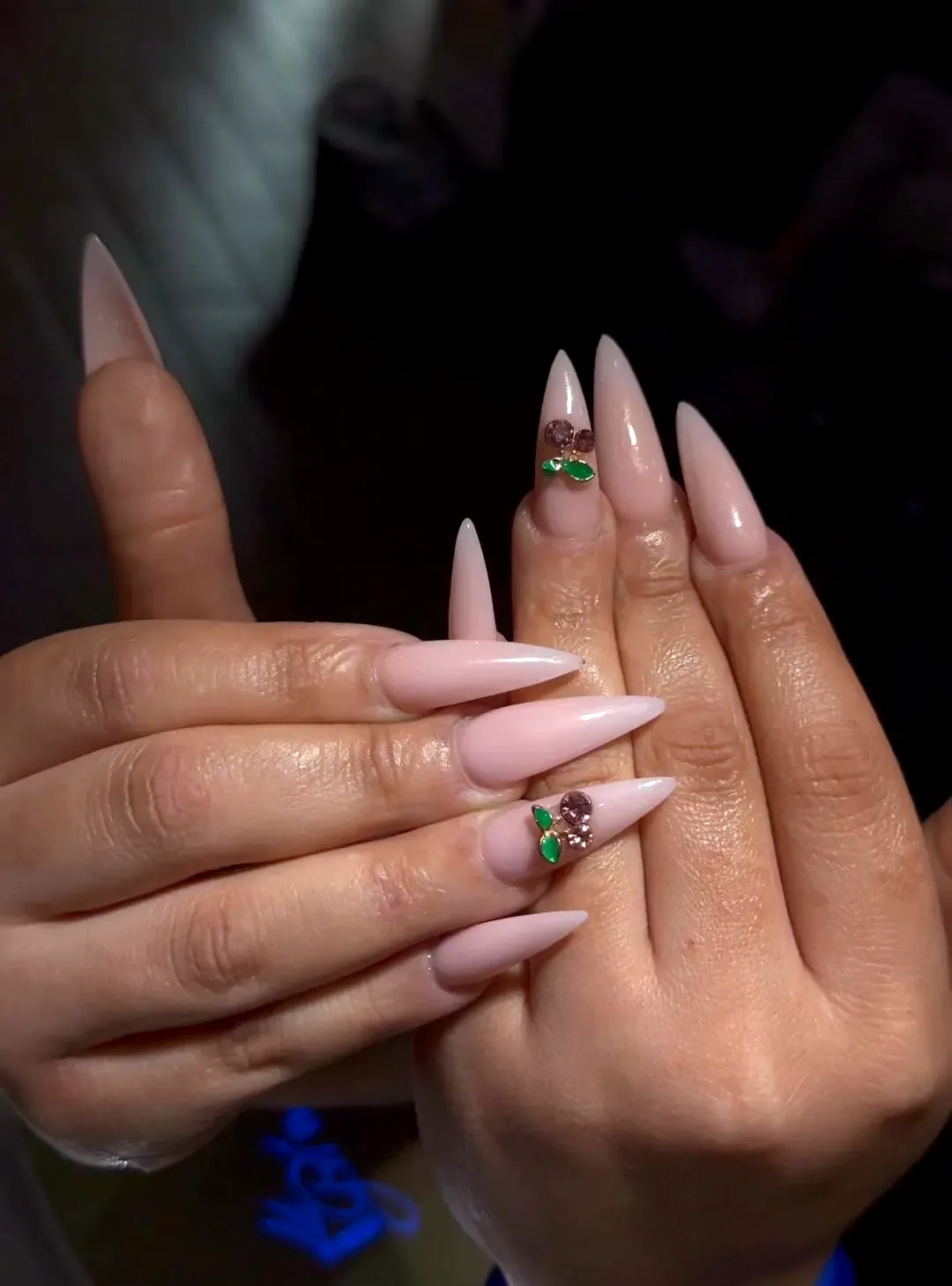 Nude stiletto nails with hand-placed cherry art at Numii
